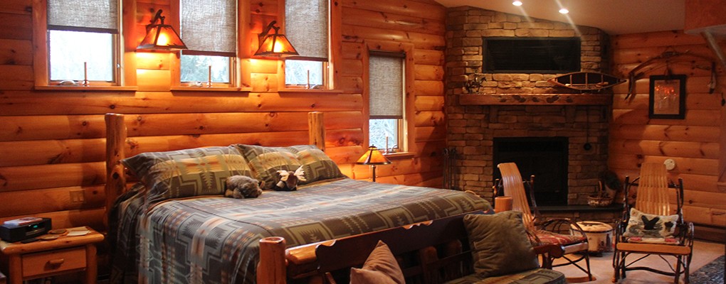 The Cheyenne Suite — king log bed, fireplace, and warm lamplight